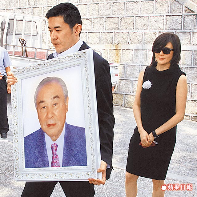 关山遗照由儿子(左)捧着,女儿关之琳神情哀伤.香港